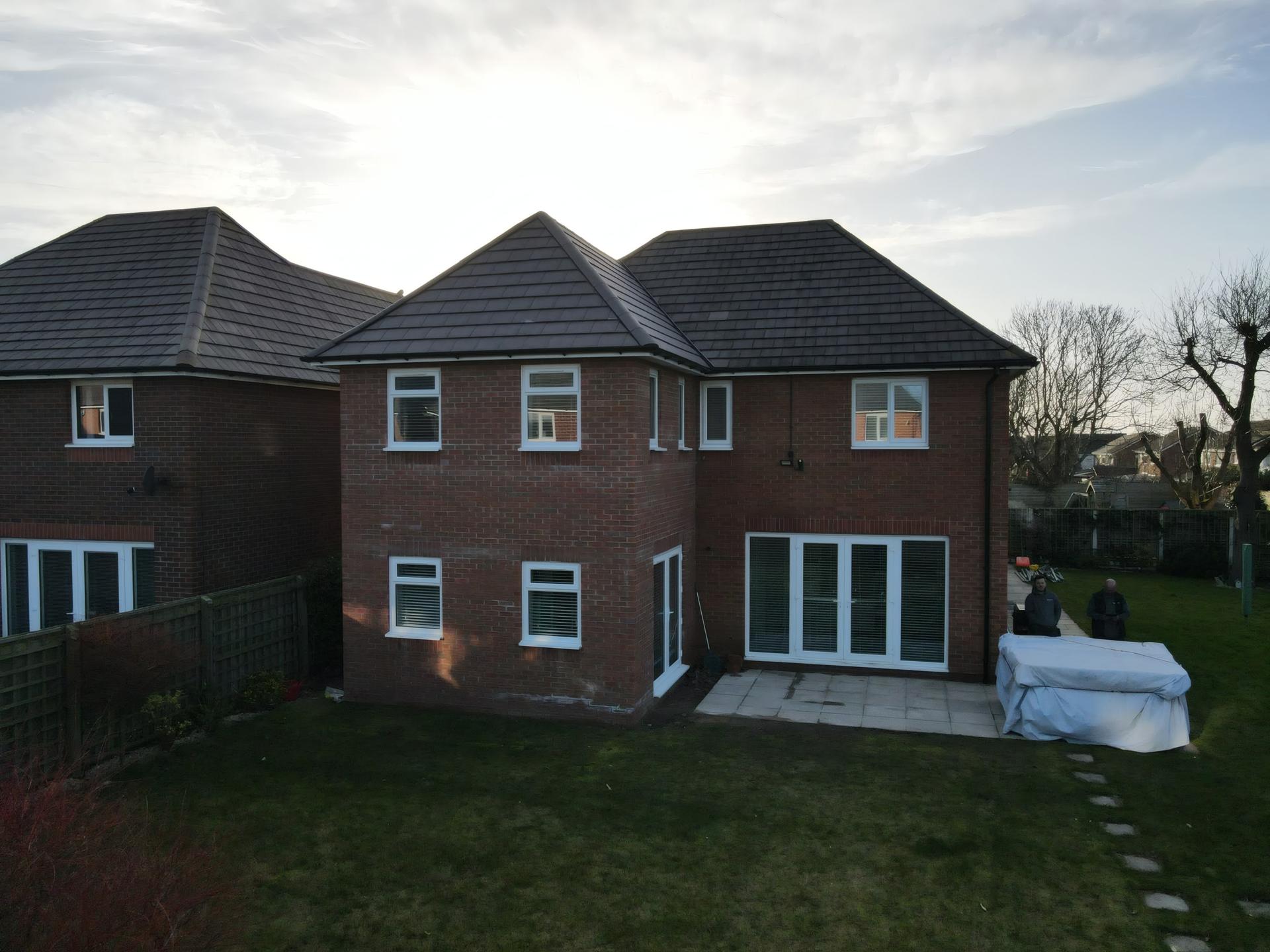 Two storey red brick house extension with hipped roof and patio doors in Maghull