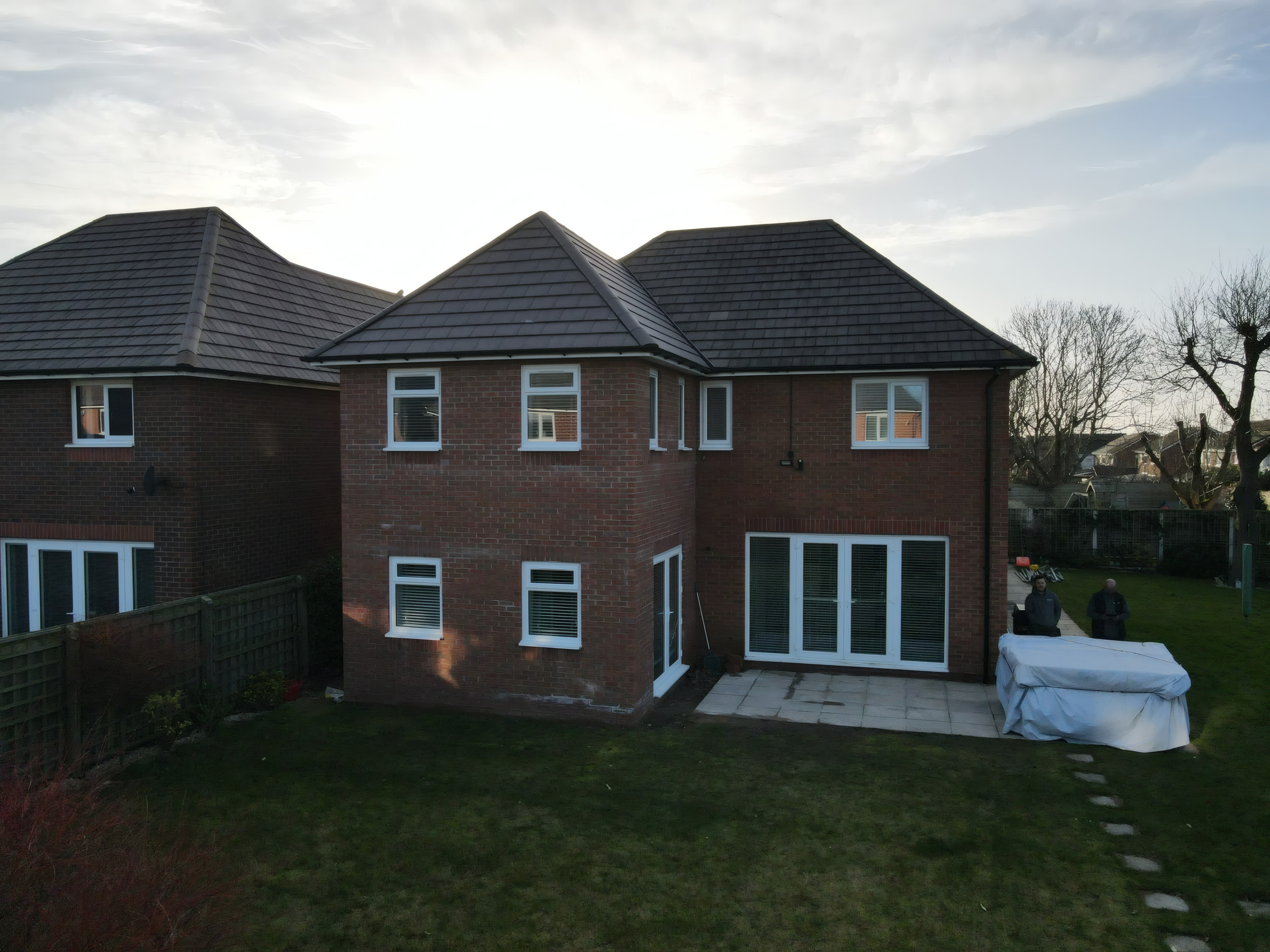 Two storey red brick house extension with hipped roof and patio doors in Maghull