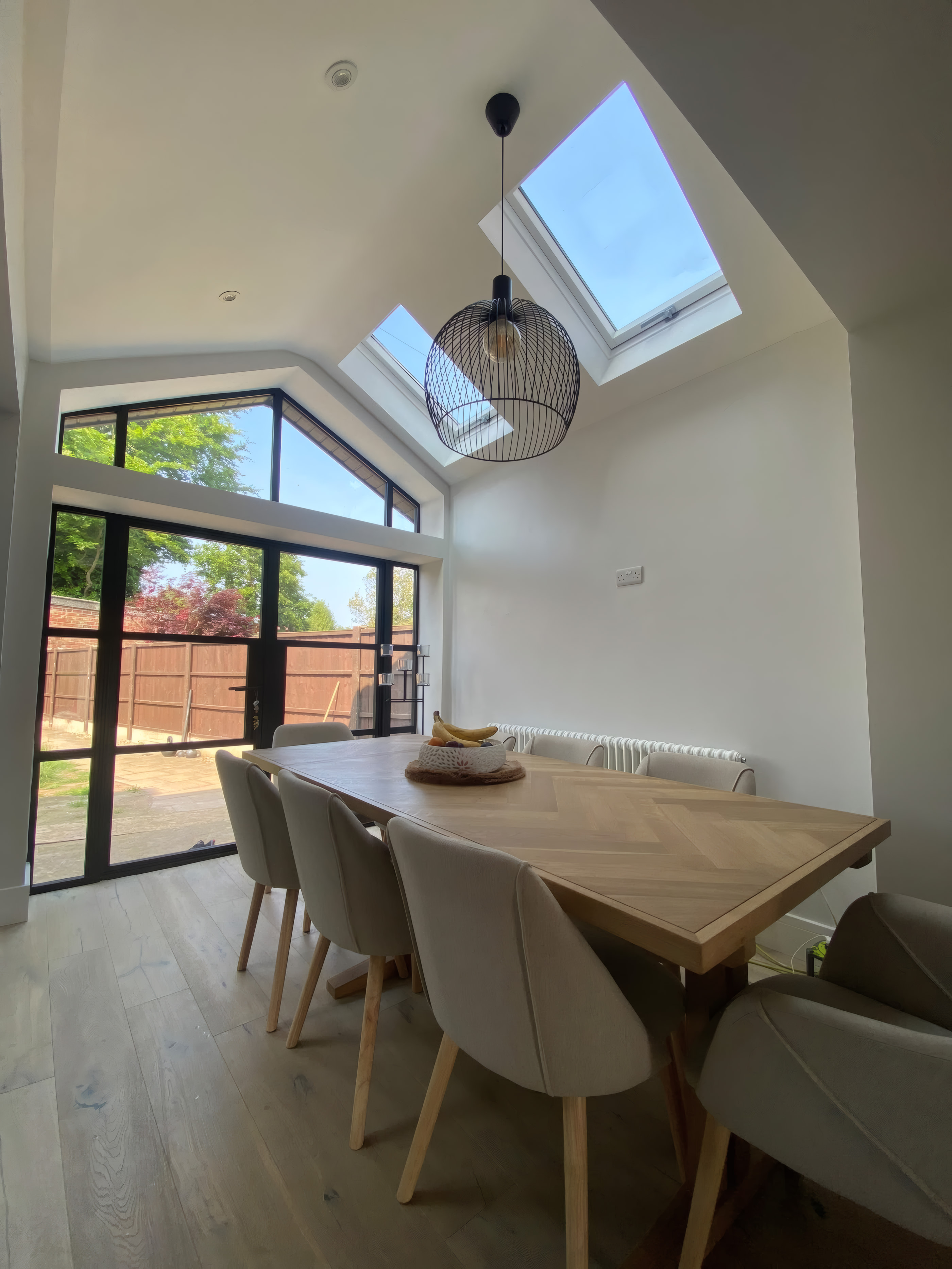 Interior of vaulted dining extension showing exposed brick pier and twin Velux windows